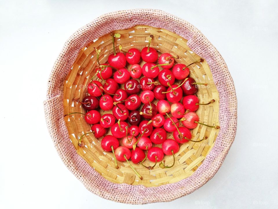 Basket with cherries on a white background