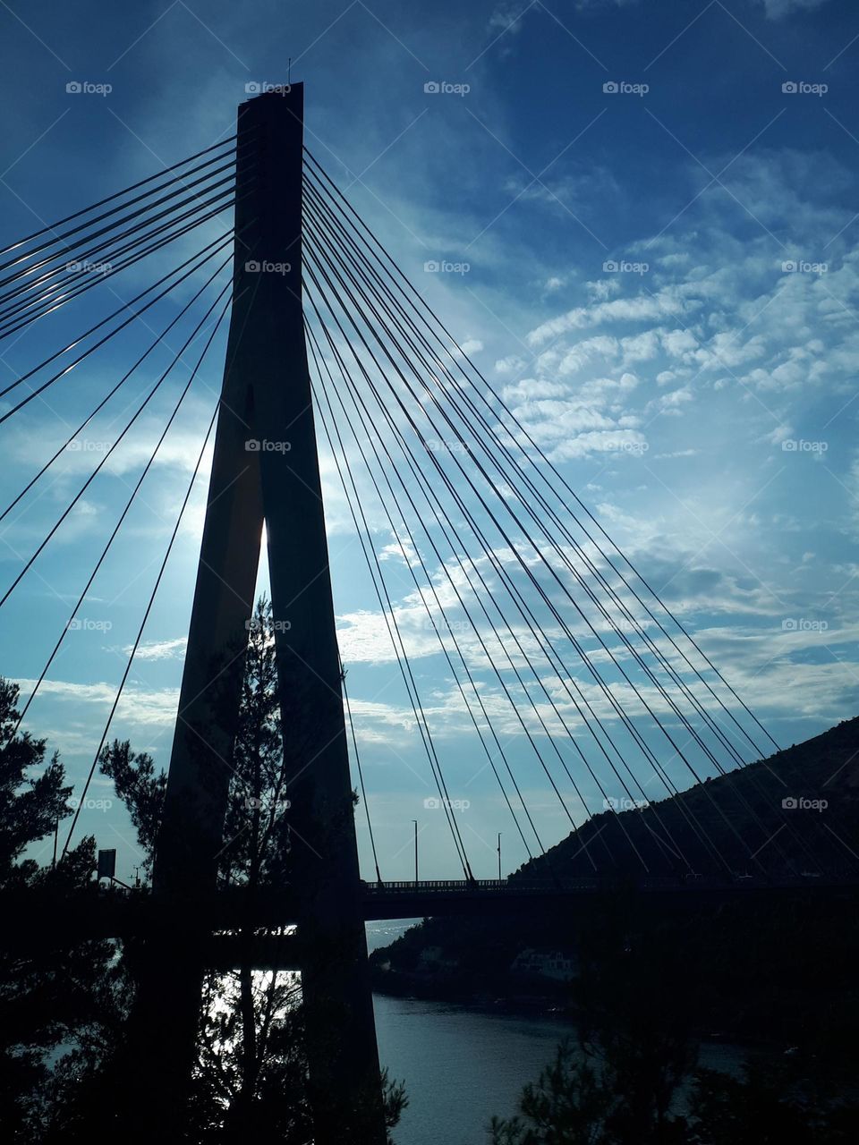 Bridge of modern architecture forming a pyramid shape with strong sun backlight.