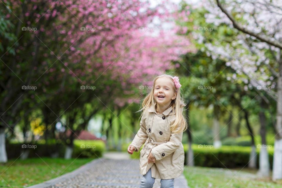 Candid lifestyle portrait of happy little Caucasian girl running outside 