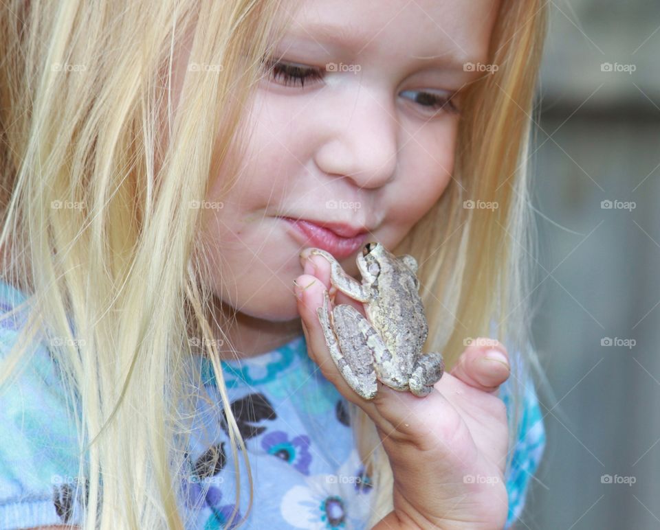 Close-up of a girl with frog on her hand