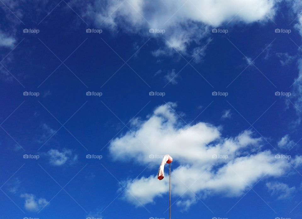 Wind indicator on the mast, on the sky background