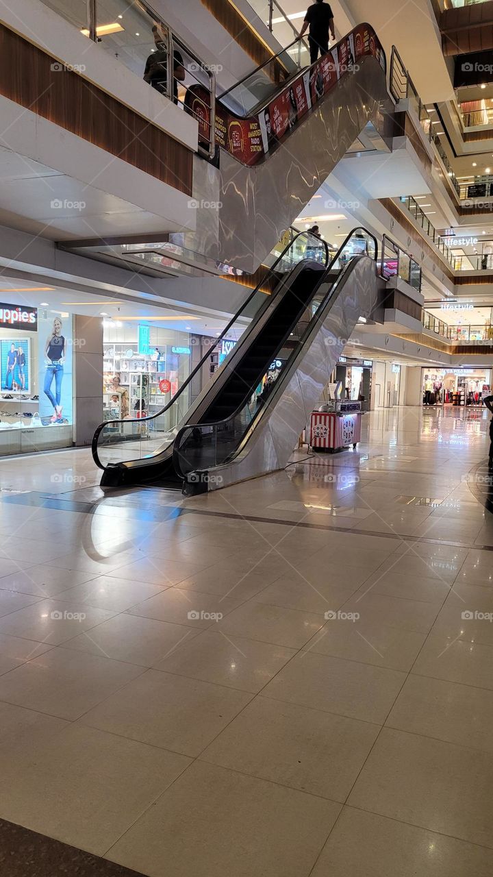 an escalator from the ground up in a mall