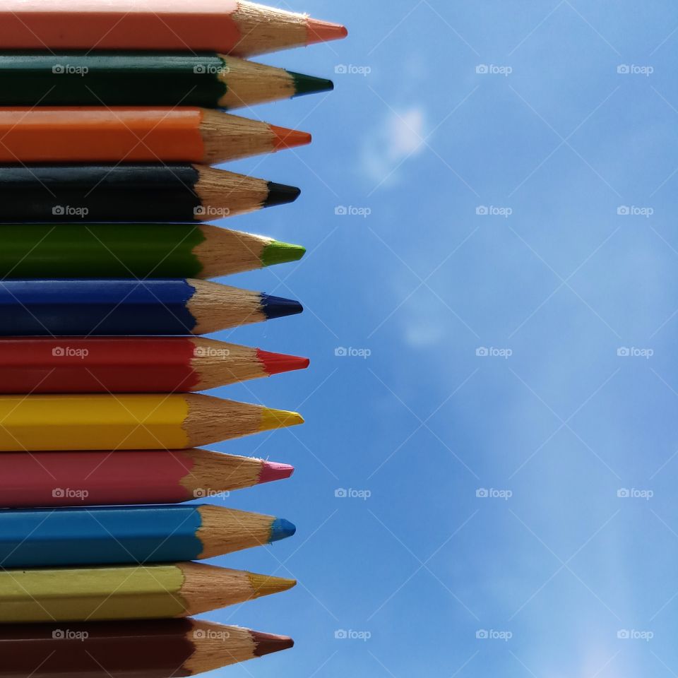 Coloring pencils and blue bright sky.