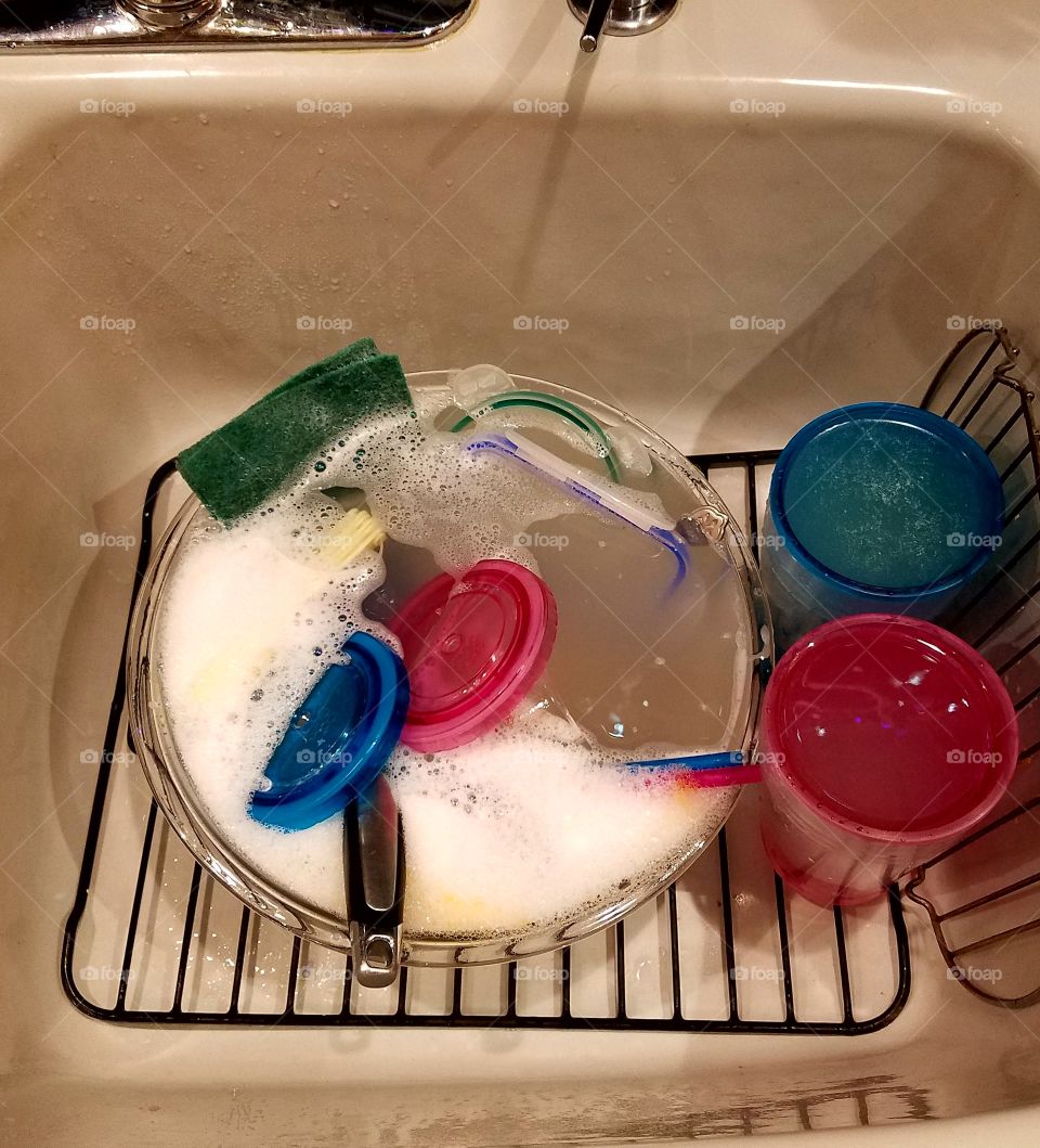 Sink full of soapy dishes to wash.