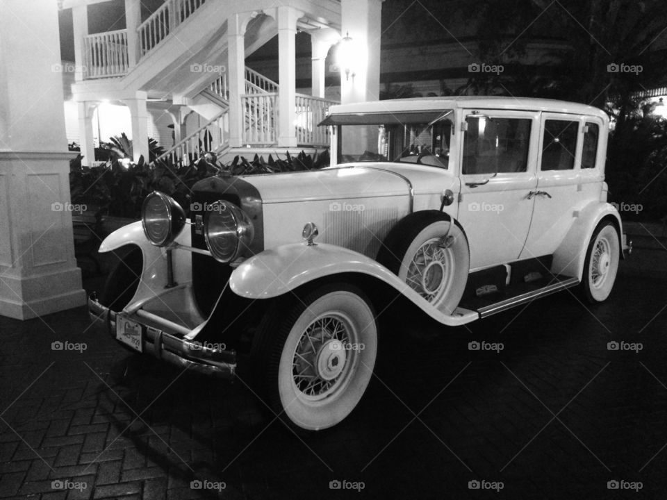 Antique automobile in black and white outside Disneyworld hotel.  