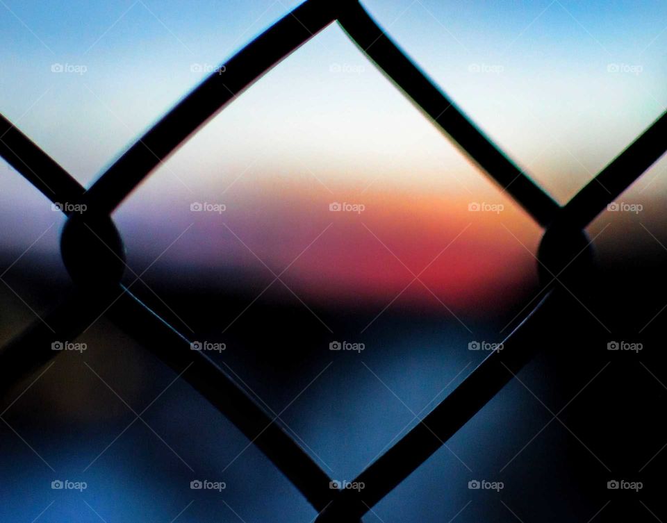 Soft blur of the sunset through a fence