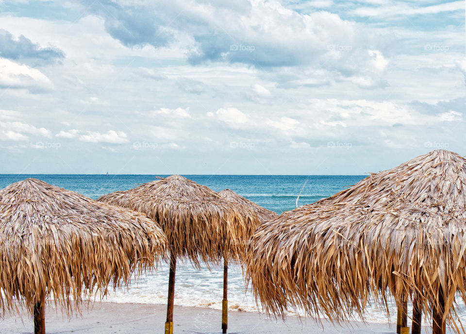 a sea horizon. a few parasols on the beach on the blue sea background
