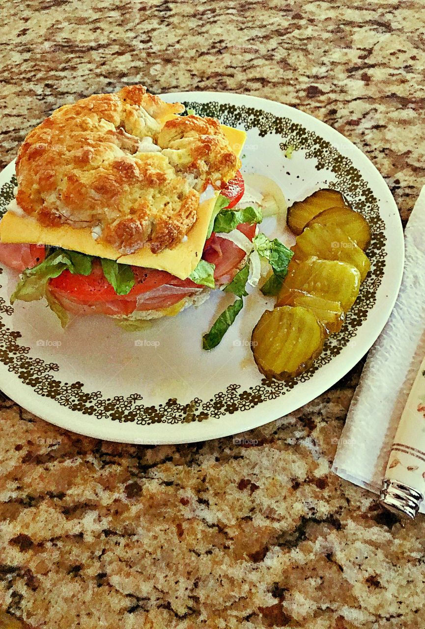 Ham&Cheese on a homemade yogurt and flour bagel with tomato, lettuce, onions! Garnish with Bread & Butter pickles!   