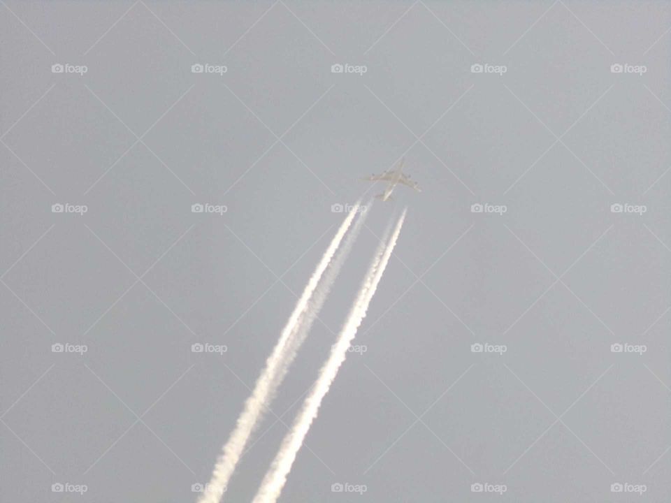 Flugzeug mit Kondensstreifen am Himmel