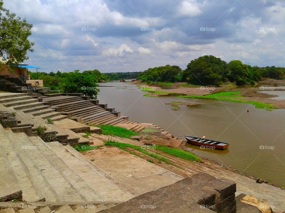 Landscape -The lonely boat in River water surrounded by colourful Nature and composition of stairs .This photograph shows peace life in with nature.