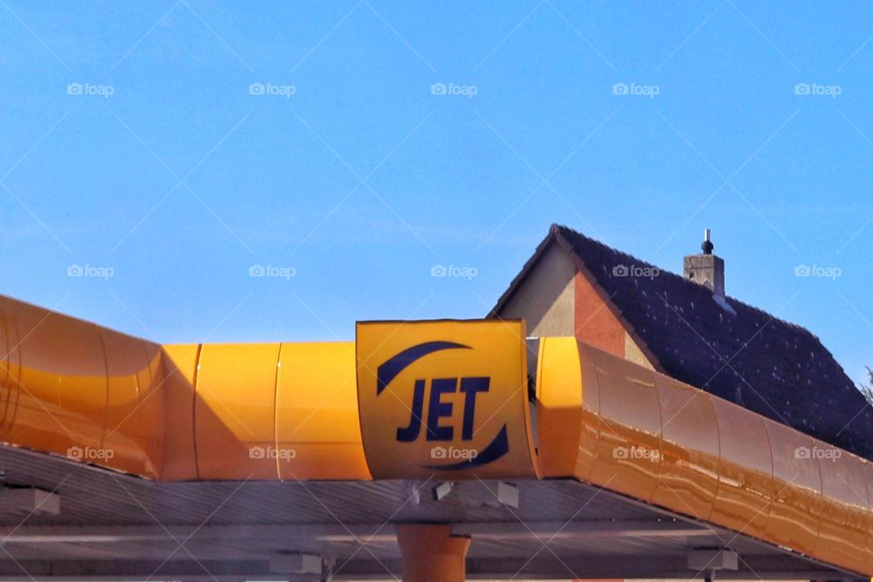Yellow JET gas stations sign in front of blue sky 