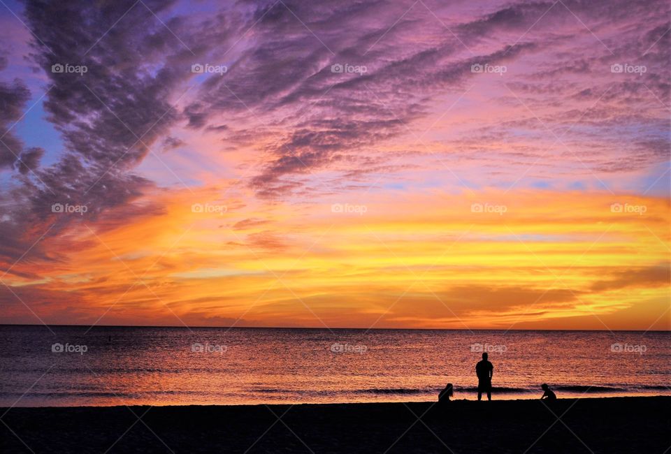 Majestic sunset on Siesta Key, Florida with a family silhouette in the foreground 