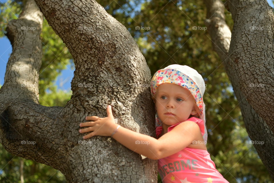 girl in a pink swimsuit on a tree