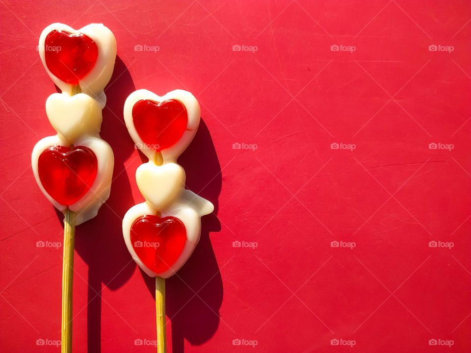 Two red and white Heart lollipop candy on red background for copy space. Minimal Valentine concept Idea