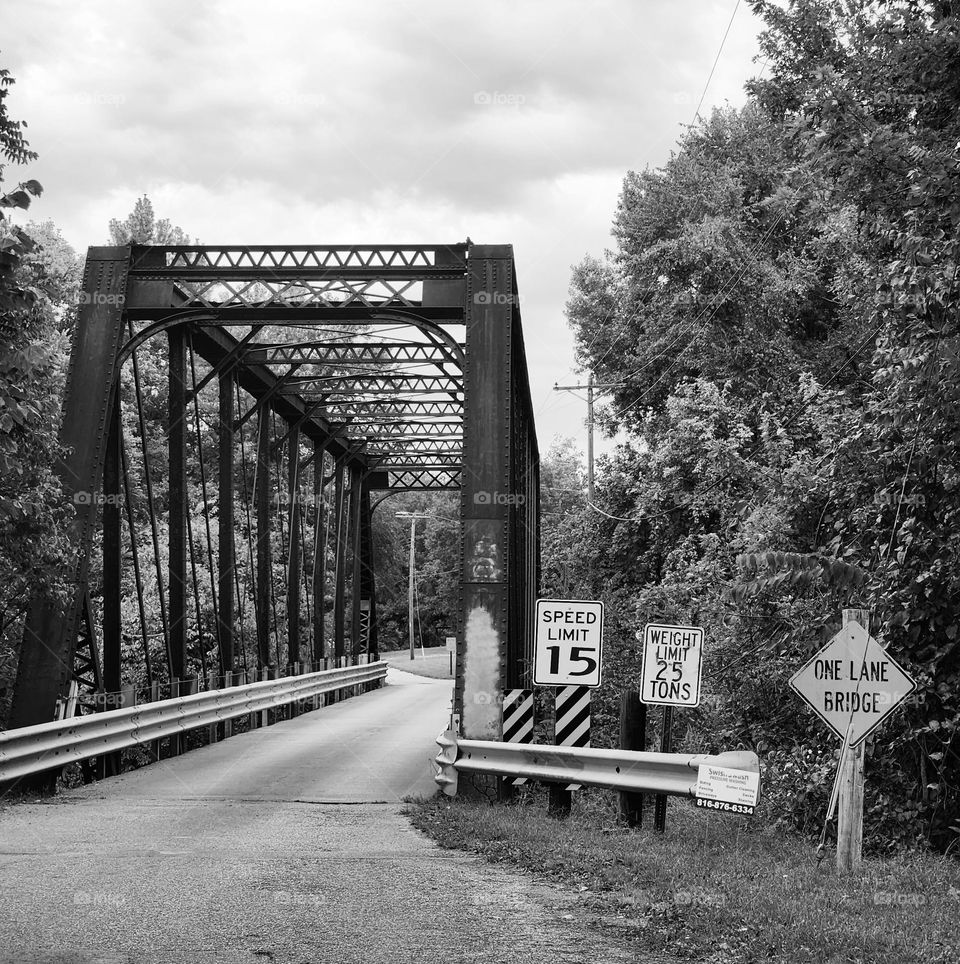 A single lane bridge high above train tracks below indicates the slow pace of a small town
