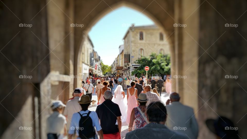 A bride, bridemaids and a crowd getting inside Camargue city center in France.