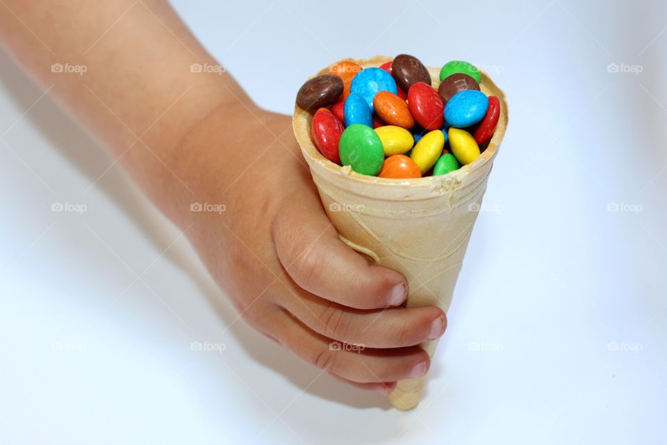 waffle cone with colored dragee in hand
