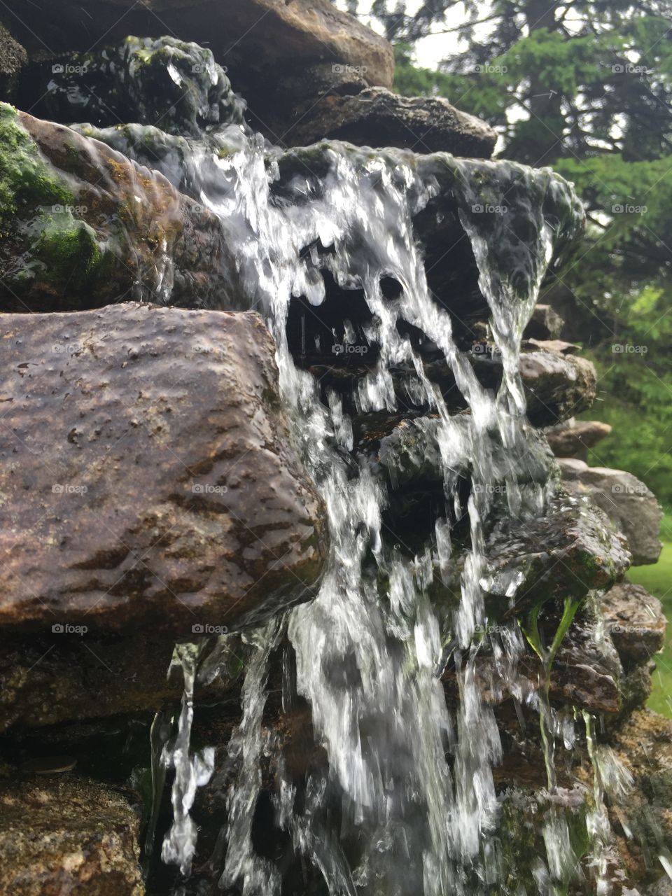 Miniature waterfall. Artisan well water running over rocks