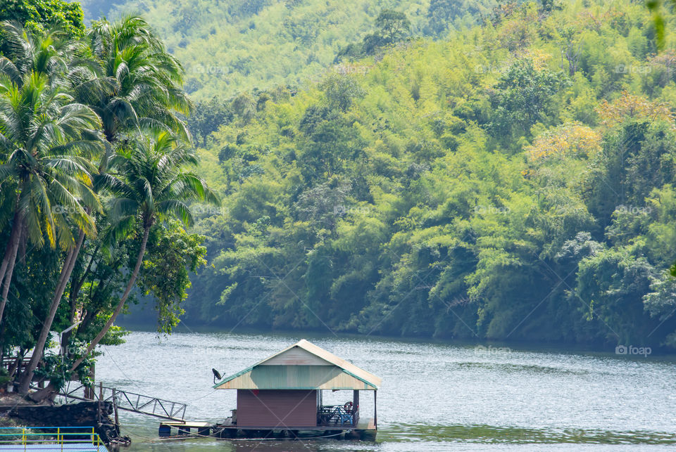 A floating raft In Kwai Yai River The background trees and mountains , Kanchanaburi in Thailand.