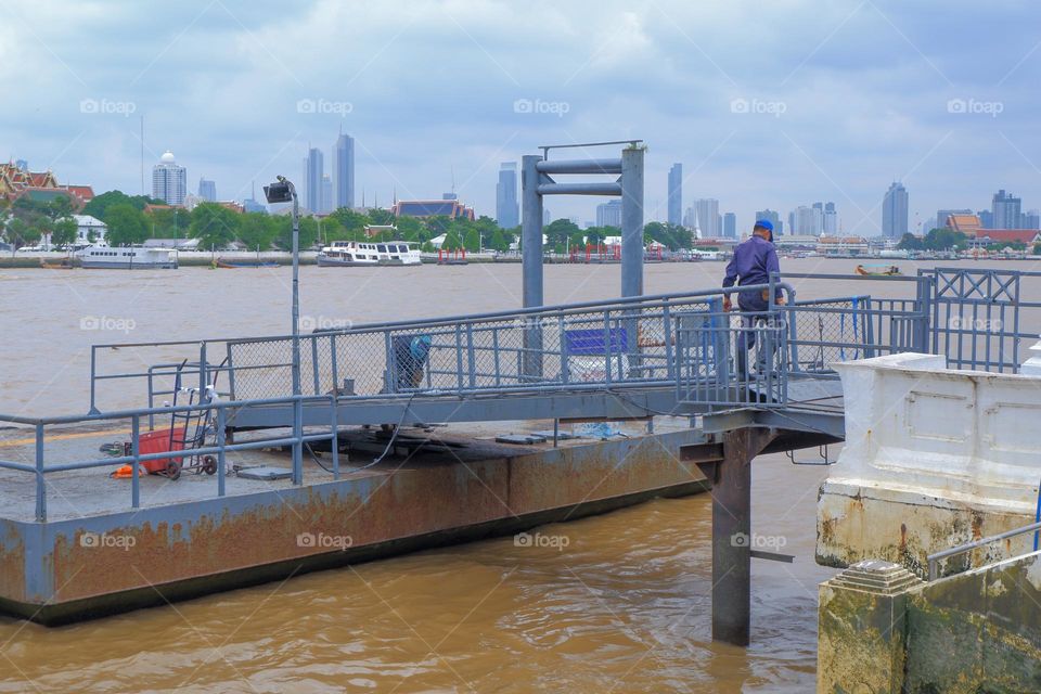 Workers are repairing the port. floating on water,River and sky background.