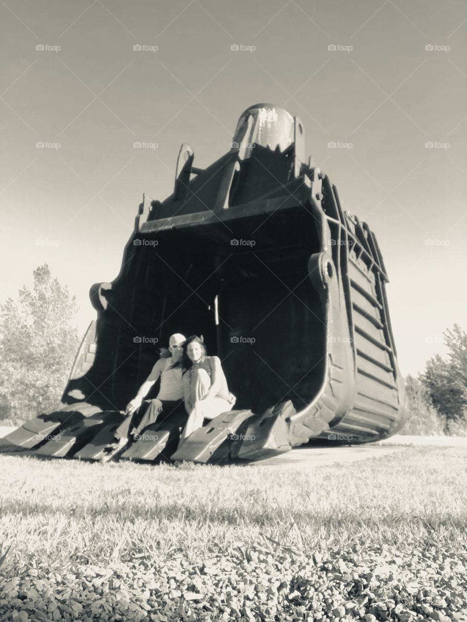 A couple sitting in the bucket used by an old cable shovel. One of three major pieces of coal mining history now on display for the public. Seeing an adult sitting in it helps you to get a concept of the large scale size of these pieces of history. 