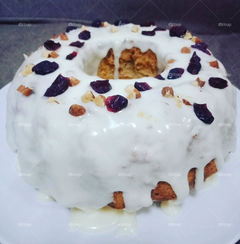 apple bundt cake with nuts, dried fruits and cream cheese icing