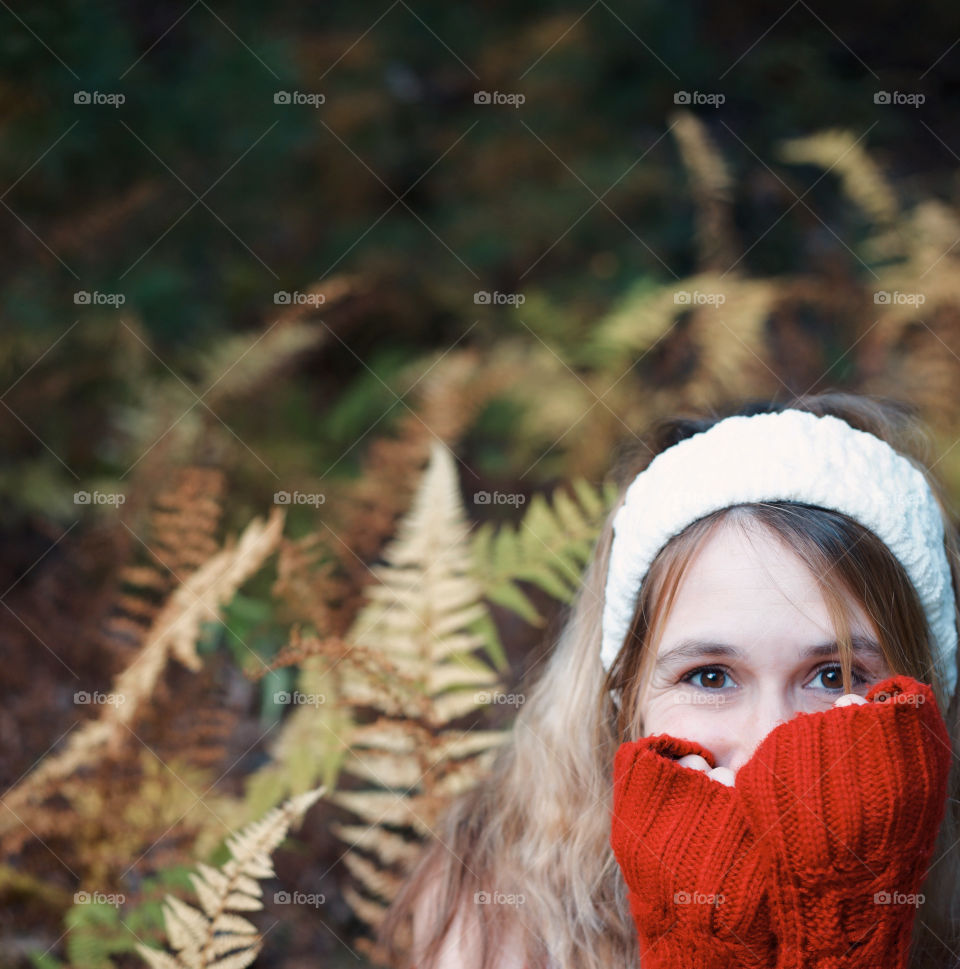 Among the Ferns; A young woman in cool Autumn clothing sitting among color changing ferns
