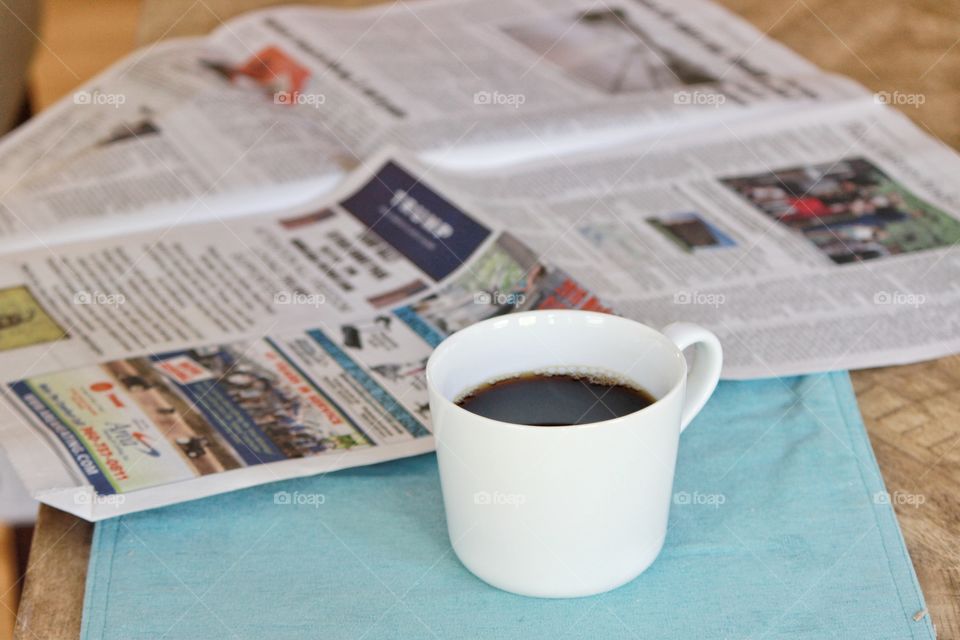 coffee mug and newspaper on a table
