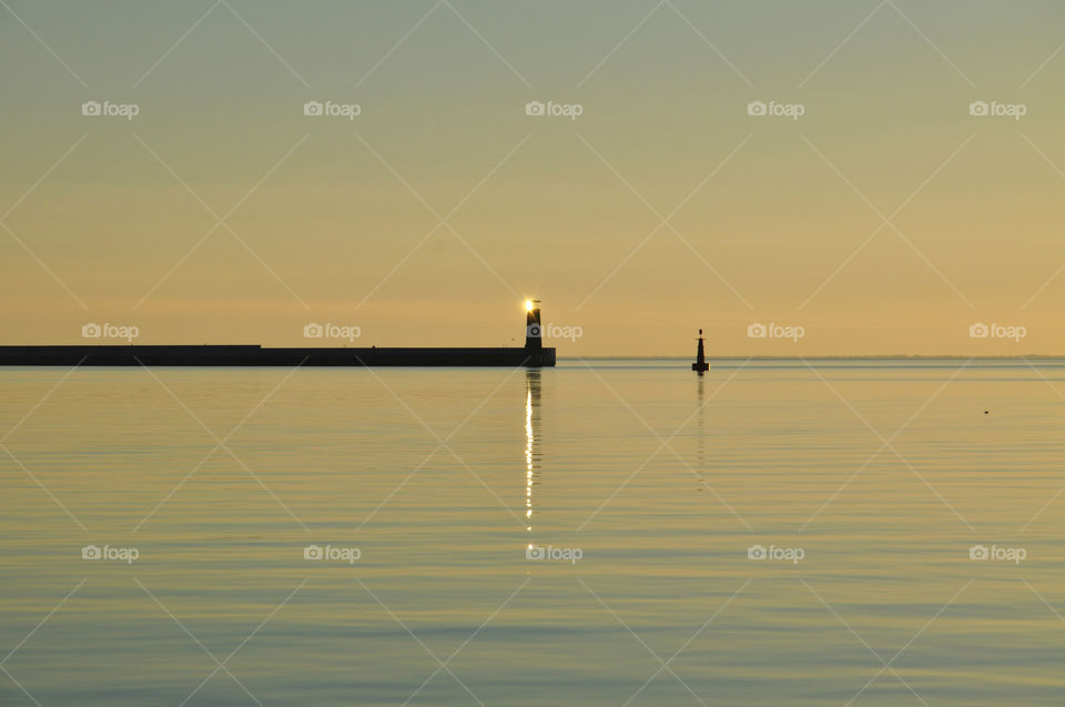 minimalistic shot with lighthouse during sunrise over the baltic sea in poland