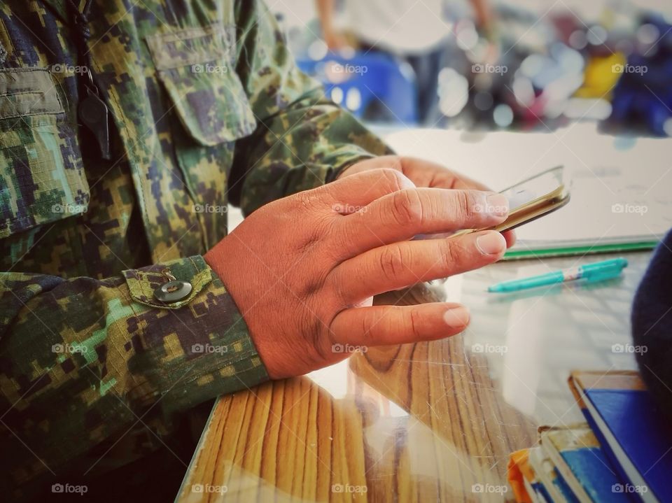 Volunteer guarding territory is playing mobile phone.