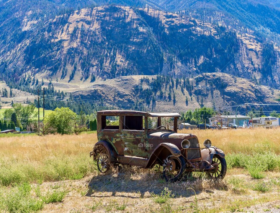 Old historic car on display in field 