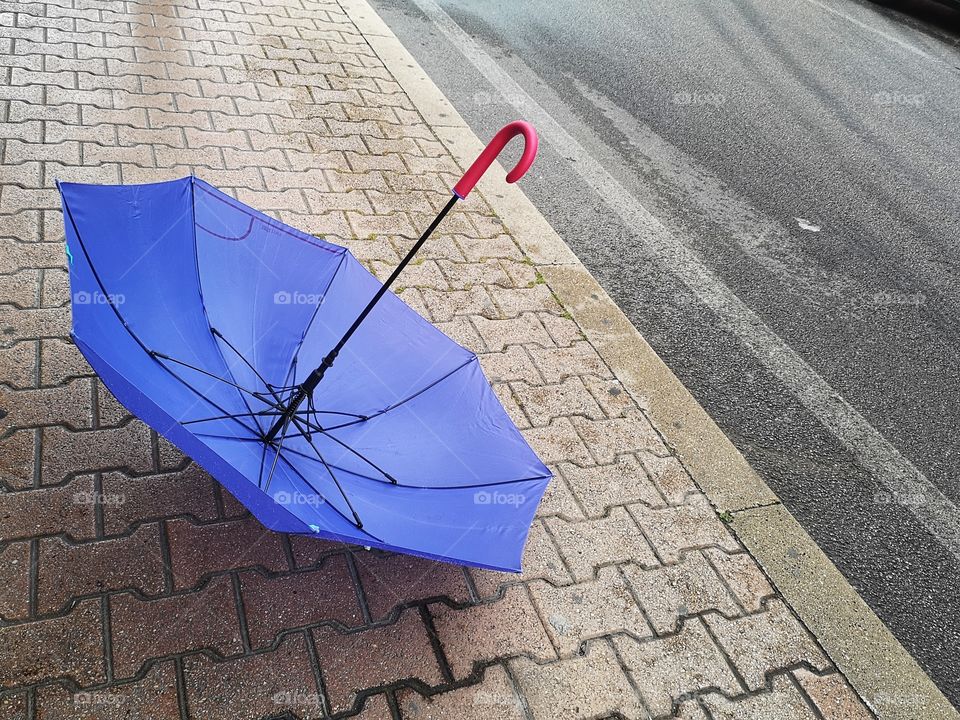 umbrella abandoned on the street on a rainy day