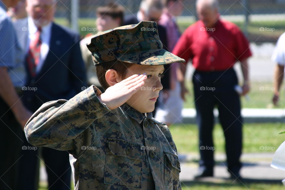 Boy wearing Army uniform salutes at veteran’s funeral 