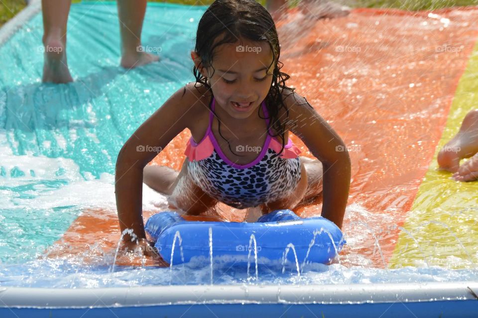 Girl sliding with float in water