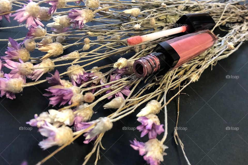 Lip Brilliance Artdeco on background of flowers