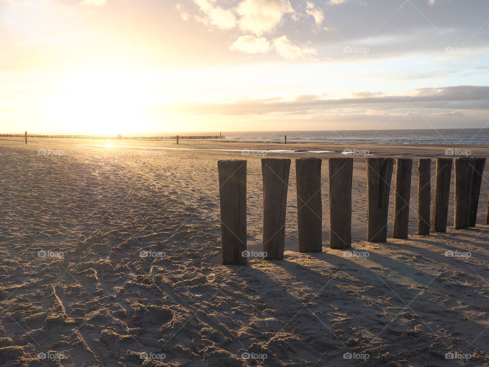 Golden sunset at the beach in Zealand, the Netherlands with view on the ocean and the seaside.