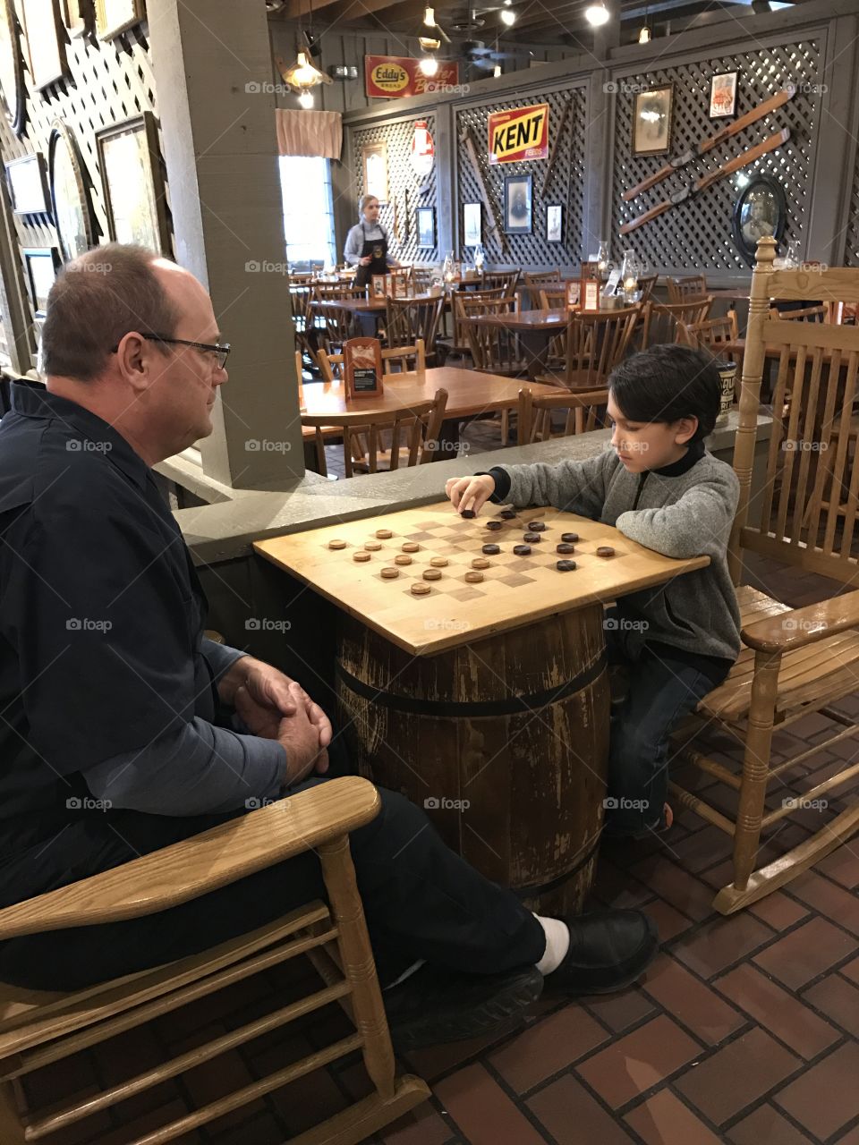 Son and dad playing checkers at Cracker Barrel