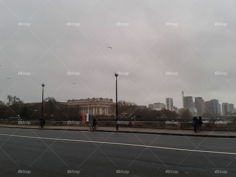 People walking in the streets of Paris while the weather is cold and foggy