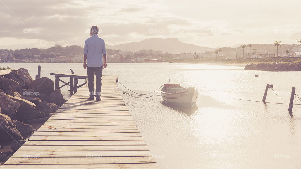 Rear view of man standing on pier