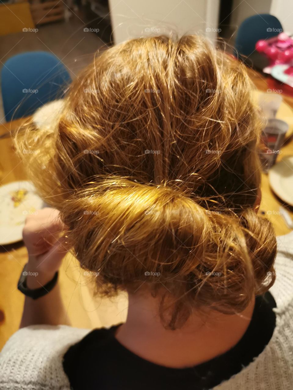 hair twisted in a bun on the back of the head.