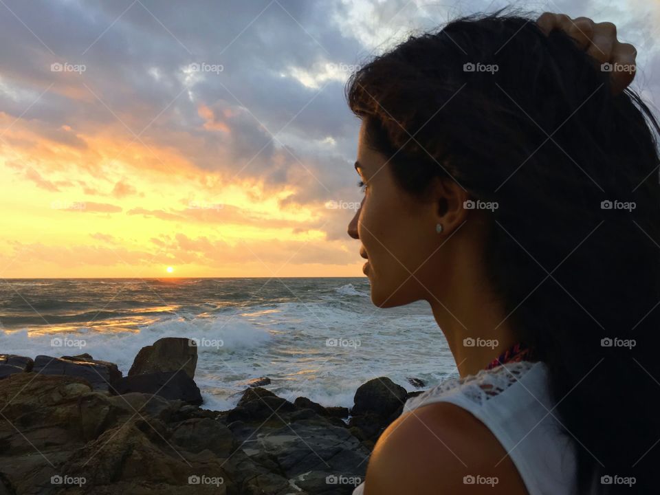Close-up portrait of a beautiful woman on the sunset sky