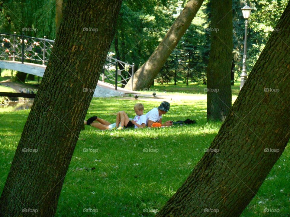 father and son resting in the park on the green grass