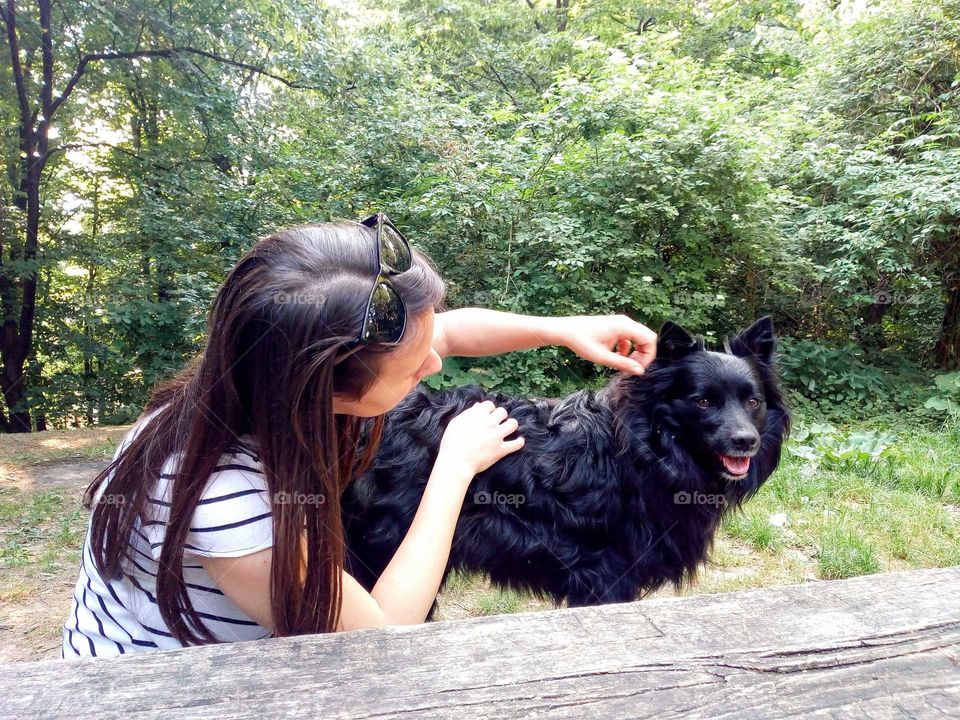 The girl tease a dog in the forest