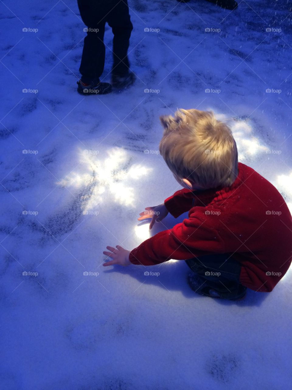 Winter Magic. Boy enjoying snow indoors and light snowflakes