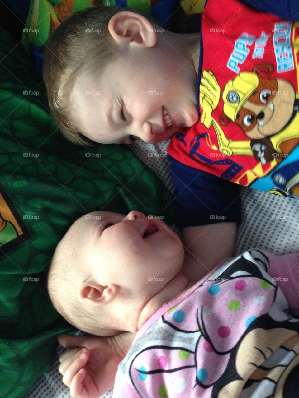 Two brothers lying on bed