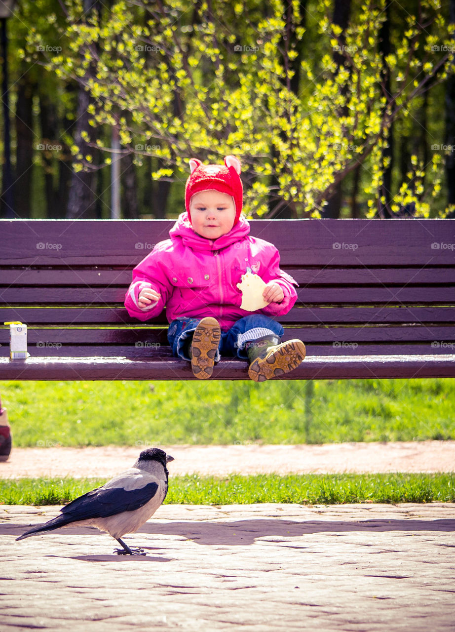 little girl is feeding a bird