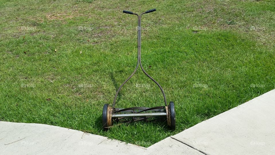 Old Style Lawnmower Alone In The Yard