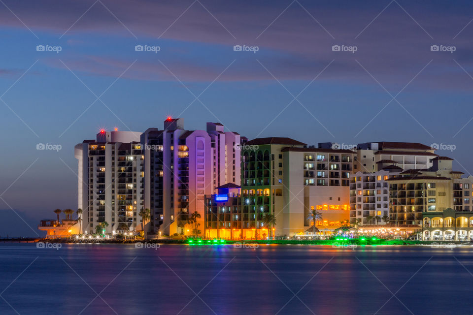 colorful skyline of beachfront resorts and nightclubs set against a blue hour sky