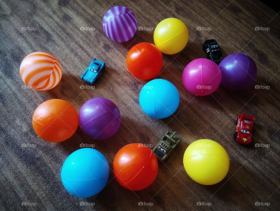 His colourful ball and small cars . 
playing together