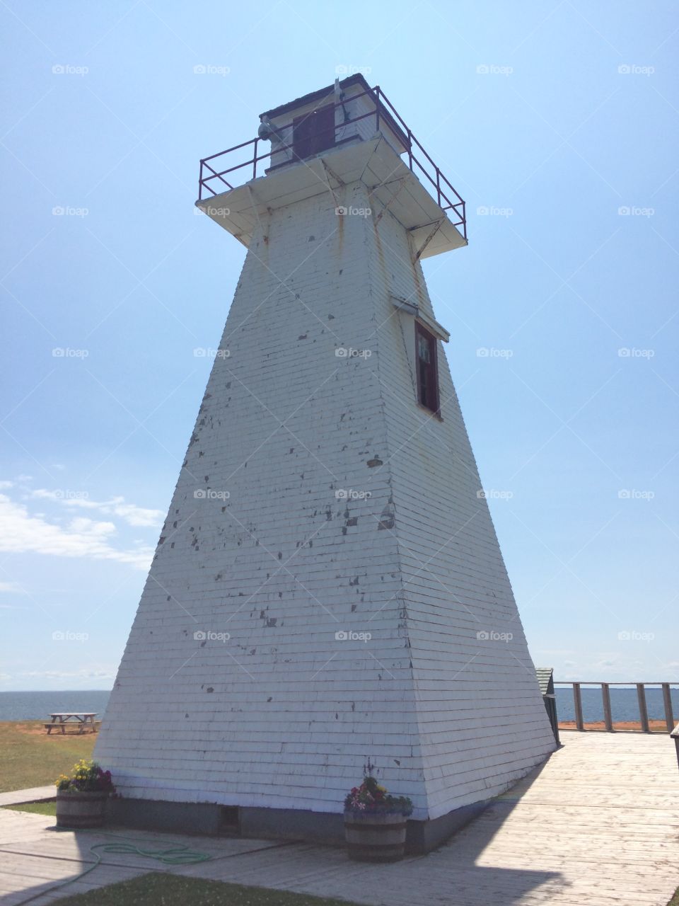 An iconic lighthouse situated on the shore of Prince Edward Island, right next to the famous Confederation Bridge.